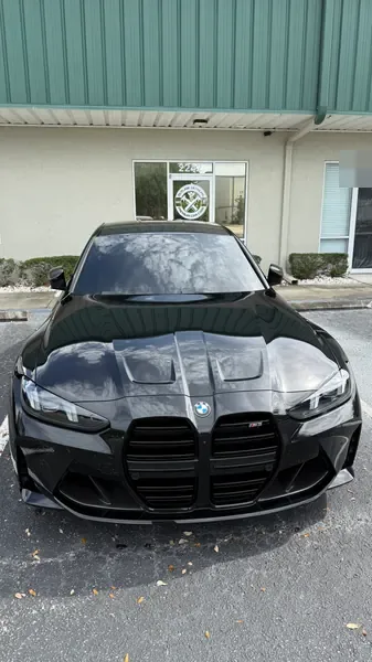 Black BMW front view with a glossy hood, ceramic coating client in Sarasota