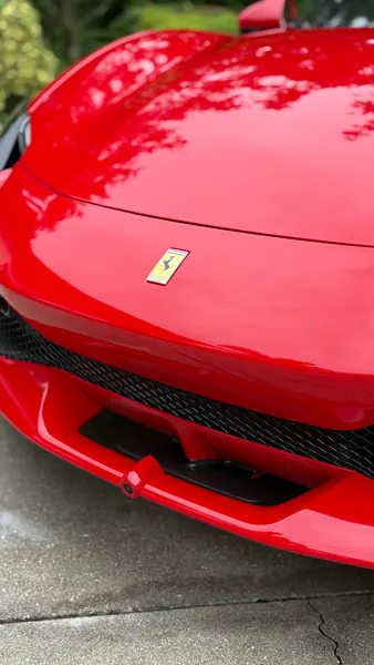 Close-up of the glossy red hood and Ferrari badge on a 296