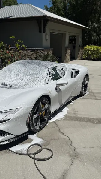 White Ferrari covered in foam during a mobile wash