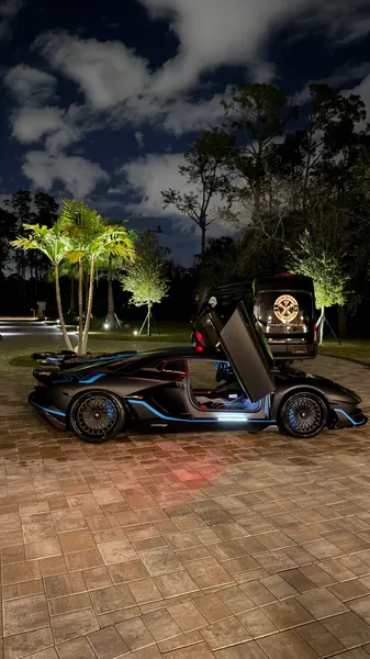 Lamborghini with scissor doors raised at dusk