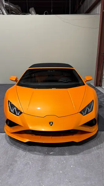 Orange Lamborghini Huracán front view on a garage floor, ceramic coating client in Sarasota